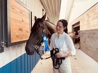 a woman standing next to a horse in a barn